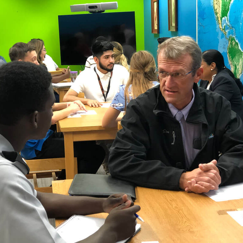 jamie french right speaks with student during networking event at lely high school